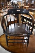 A 19th Century oak captains chair having spindle back and turned double stretcher rail to front