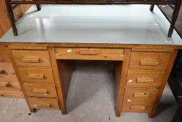 A vintage golden oak desk having formica top, dimensions approx. W114 H76 D68cm