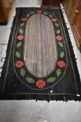 A vintage pegged style rug , having striped decoration with foliate border, approx 220 x 110cm