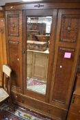 An early 20th Century oak mirror door wardrobe having drawer base, dimensions approx. H197 W118