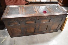 A period oak four panelled kist having carved frieze, dimensions approx. W138cm H69cm D52cm