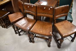 A set of four early 20th Century oak and leather dining chairs, having interesting vine design to