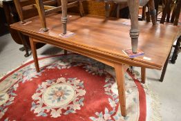 A vintage teak coffee table of stylised design, having fold out top, closed size 140 x 60cm