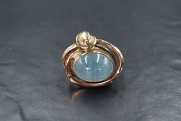 A silver and yellow metal blue cabochon possibly aquamarine set artisan ring, likely a scarf ring,