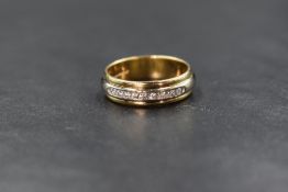 An 18ct two tone diamond set band, the central raised band set with nine round brilliant cut