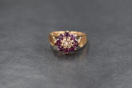 A 9ct gold ruby and diamond set cluster ring, the illusion set diamond chip in a eight round cut