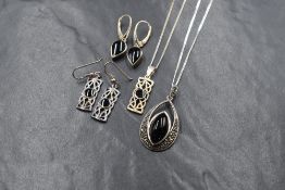 A suite of silver and jet jewellery, comprising a necklace and drop earrings, the central bezel