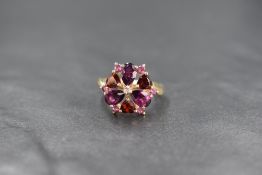 A 9ct gold garnet and amethyst open daisy cluster ring by QVC, having heart cut garnets interspersed