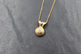 An 18ct white & yellow gold diamond solitaire pendant, the brilliant cut diamond of approx 0.05ct in