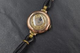 A ladies vintage 9ct rose gold wrist watch having an Arabic numeral dial to gold coloured face on