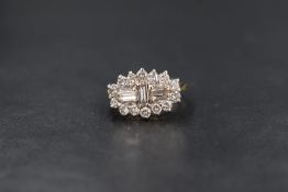 An 18ct gold diamond cluster ring having a vertical set baguette cut diamond between two further