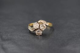 A yellow metal presumed gold diamond set trefoil ring, the three round brilliant cut diamonds