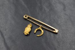 A 9ct rose gold bar brooch of plain form and two 9ct gold charms, owl & horseshoe, 4g