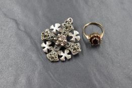 A 9ct gold garnet set cluster ring, the central oval cut garnet in a twelve garnet surround,