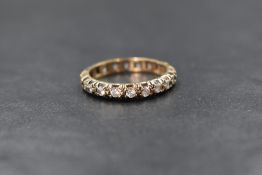 A 9ct gold paste set full eternity band, rubbed 9ct mark, ring size Q, 3.1g
