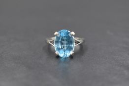 An 18ct white gold blue topaz ring having a large oval cut stone, 14mm x 10mm, in a four claw raised