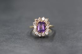 A 9ct gold amethyst and cubic zirconia cluster ring, having a baguette cut amethyst within a