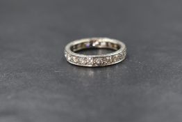 A white metal diamond set full eternity ring having twenty one pave set diamonds total approx 1ct,