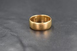A yellow metal wedding band of plain form, no marks but presumed 18 or 22ct gold, size R & 8.2g