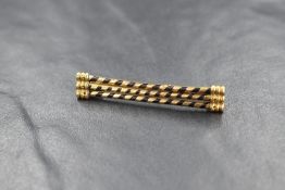 A yellow metal presumed gold hair brooch, having three bars of hair (possibly elephant) wrapped in