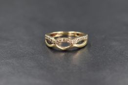 A 9ct gold diamond chip set band, the openwork infinity band having diamond chips set to one side,