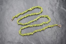 A rough cut peridot necklace having a 9ct rose gold clasp, approx 18' long