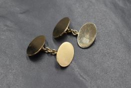 A pair of 9ct gold cufflinks, the oval panels of plain form having chain links, marked 375, 9.7g