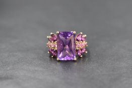 A 9ct gold amethyst ring by QVC, having a large emerald cut amethyst flanked by marquise and