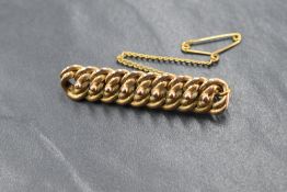 A yellow metal brooch modelled as a piece of double link chain, no marks but tests as 9ct gold,