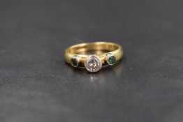 An 18ct gold band ring having a central diamond in a raised collared mount, approx 0.45ct flanked by