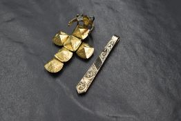 A 9ct gold tie slide, having decorative scroll engraving, marked 375, 3.4g, along with a