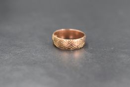 A 9ct rose gold wedding band having engraved decoration, size K & 2.8g