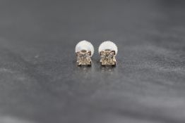 A pair of princess cut diamond solitaire earrings, each approx 0.45ct in four claw set mounts with