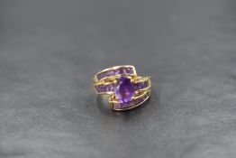 A 9ct gold amethyst ring by QVC having a central oval amethyst on a princess cut amethyst set band