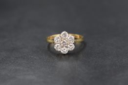 An 18ct gold daisy cluster ring having seven brilliant cut diamonds totalling approx 1ct in a claw