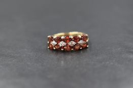A 9ct gold fire opal ring having two rows of five fire opals with two central diamond chips in