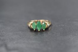 A 9ct gold emerald and diamond set ring, the three graduated marquise cut emeralds having split