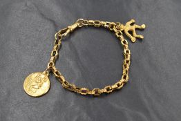 A yellow metal bracelet having moulded loop links, dog leash clasp and a monkey charm and St