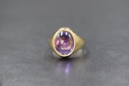A 9ct gold amethyst set signet style ring, the central oval amethyst in a bezel setting, marked 375,
