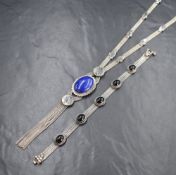 A white metal triple strand necklace stamped 900 having a central lapis lazuli oval cabochon with