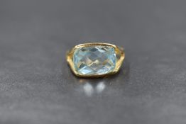 An 18ct gold aquamarine set ring, the horizontal oval rose cut aquamarine measuring approximately