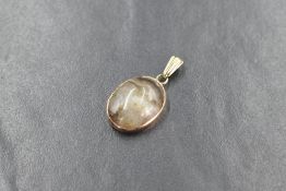 A yellow metal presumed gold agate set pendant, the oval agate cabochon in a bezel setting,
