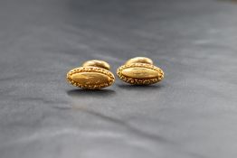 A pair of yellow metal cufflinks stamped 14K having moulded oval panels bearing monogram J with