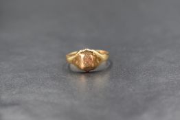 An 18ct gold signet ring, the worn shield motif having a rubbed monogram, marked 18ct with