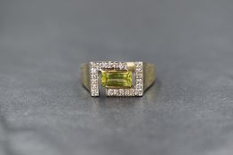 A 9ct gold peridot and diamond set signet style ring, the central baguette cut peridot within an