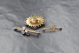 Three yellow metal brooches including a bar brooch having moonstone set central clover leaf,