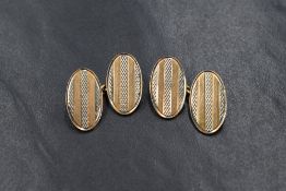 A pair of 18ct yellow & rose gold cufflinks having striped oval panels with chain connectors, approx