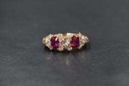 A yellow metal presumed high carat gold diamond and ruby set ring, the central old cut diamond