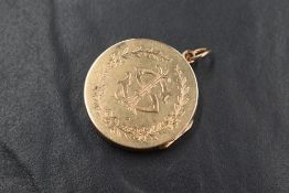 A 15ct rose gold locket, of circular form having 'SAE' monogram within a floral wreath to one side