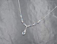 An 18ct white gold aquamarine and diamond set necklace, the six pear cut aquamarines alternating